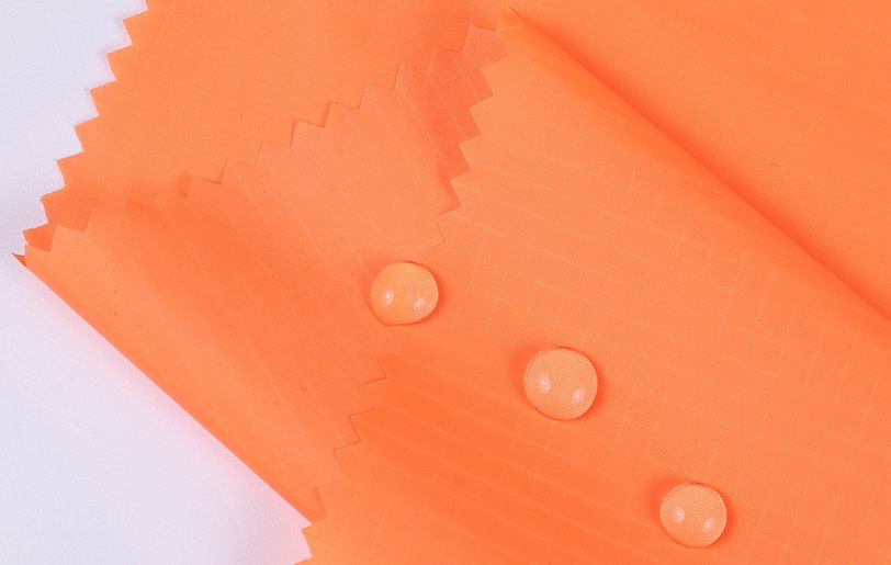 Waterproof Coatings for Bag Fabrics A visual showing a water droplet beading on a fabric with a waterproof coating